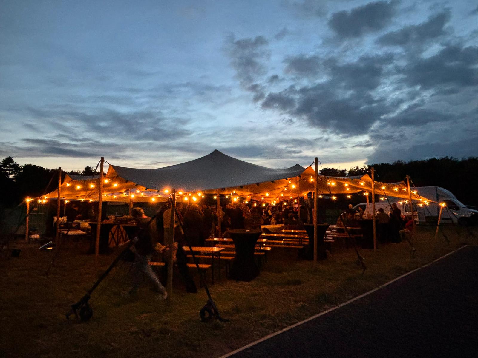 Verlichte stretchtent van Troy Verhuur tijdens een avondfeest met gasten